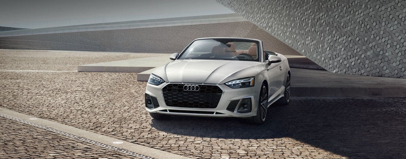 A white 2025 Audi A5 for sale parked on pavers.